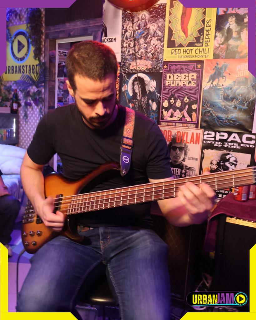 Músico apasionado tocando el bajo en el local de ensayo UrbanStart en Madrid, disponible por horas, ideal para sesiones individuales o con banda