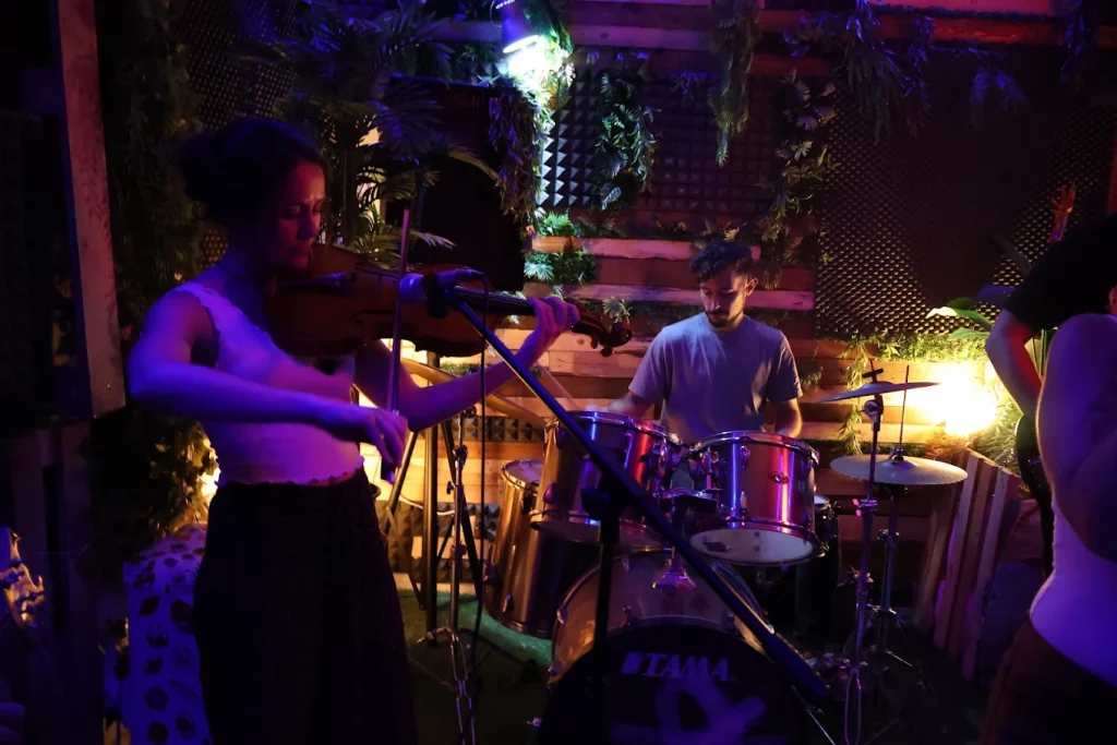 Dúo de músicos en sesión de ensayo en UrbanStart Madrid, con una violinista y un baterista, en un local disponible por horas.